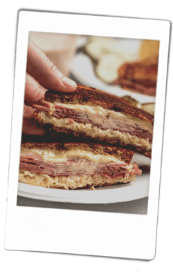 Instax picture of a Reuben grilled cheese sandwich served on Chinet Classic plates