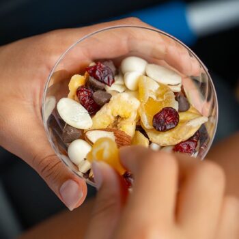 Hand holding a Chinet Crystal cup filled with trailmix