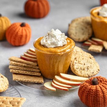 Pumpkin cream cheese in a chinet crystal cup with crackers and apples