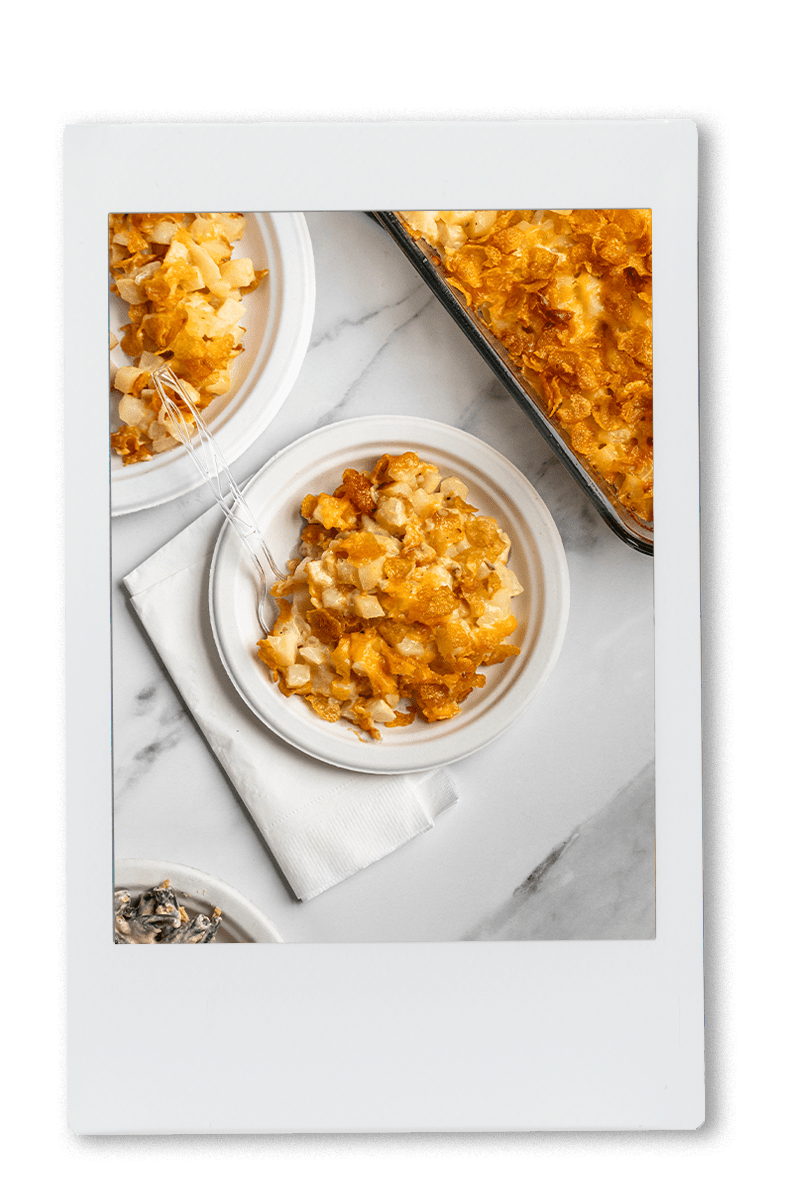 Instax of cheesy potatoes being served on a Chinet plate