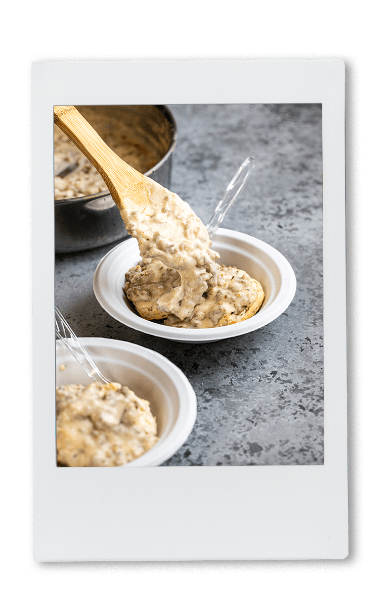 Instax of sausage and gravy being added to biscuits