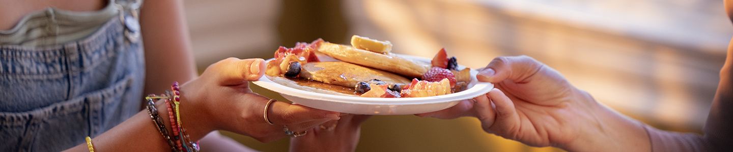 A plate of pancakes passed between hands