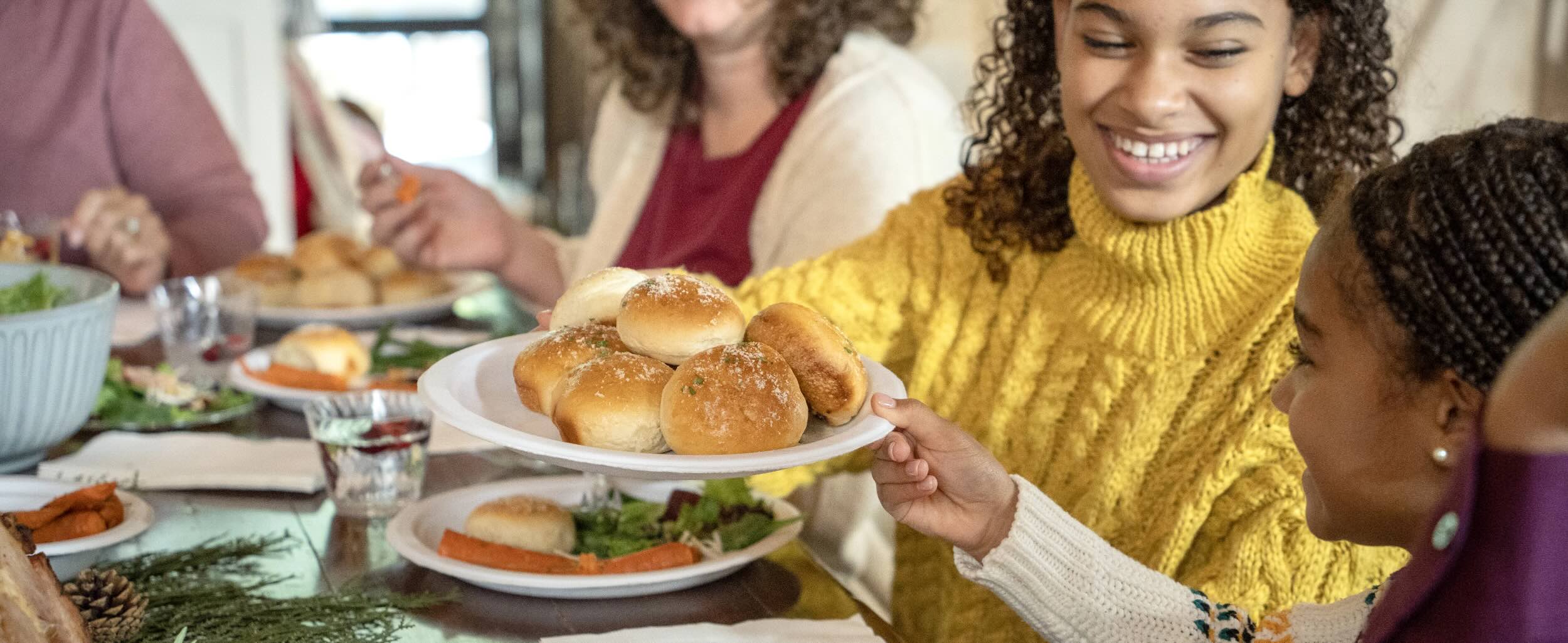 Sisters sharing rolls served on a chinet paper plate