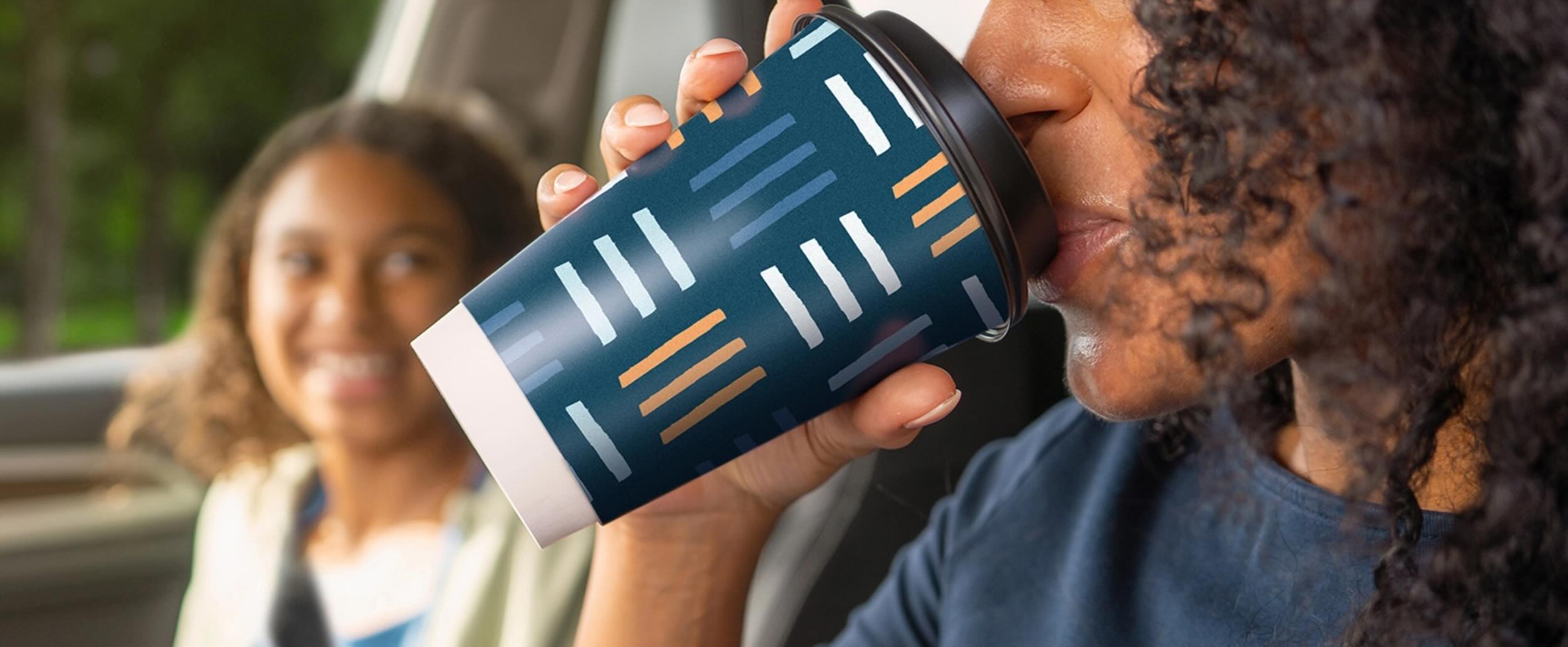 Mom drinking out of Chinet brand cup with daughter in the car