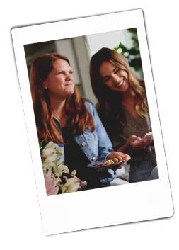 Instax picture of two women sitting on a couch laughing