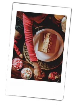 Young girls decorating a gingerbread house