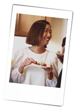 Instax picture of a woman holding a Chinet Classic plate of appetizers