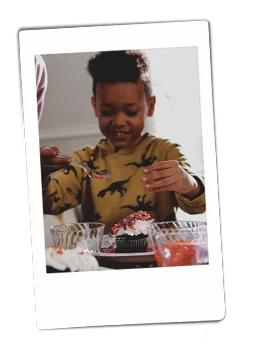 Instax of a boy decorating cupcakes