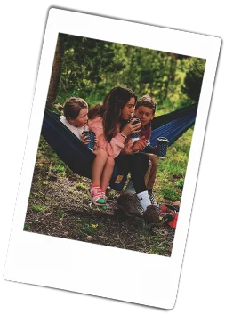 Instax picture of siblings sitting in a hammock holding Chinet Comfort cups