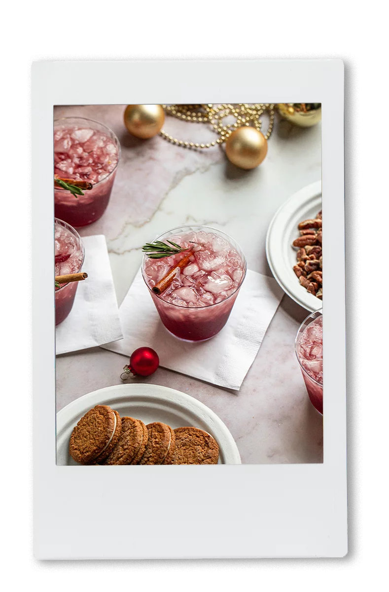 Instax picture of a table of red sangria with a cinnamon stick garnish in a Chinet Crystal cup