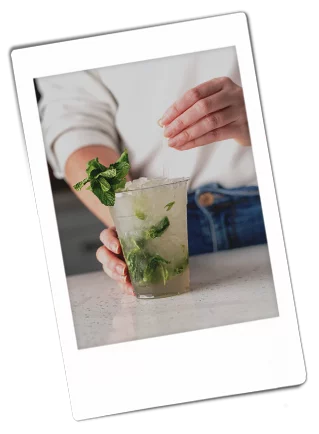 Instax picture of a woman garnishing a mojito mocktail