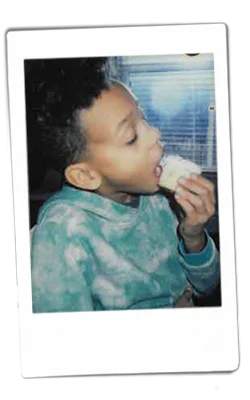 Instax picture of a boy eating a cupcake