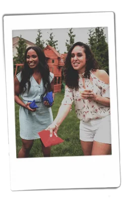 Instax of two girls paying cornhole