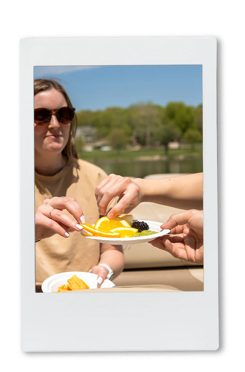 People sharing snacks on a boat on a chinet plate