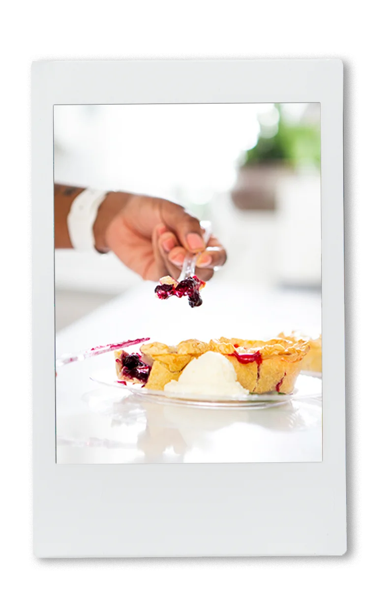 Instax picture of a hand picking up a slice of pie